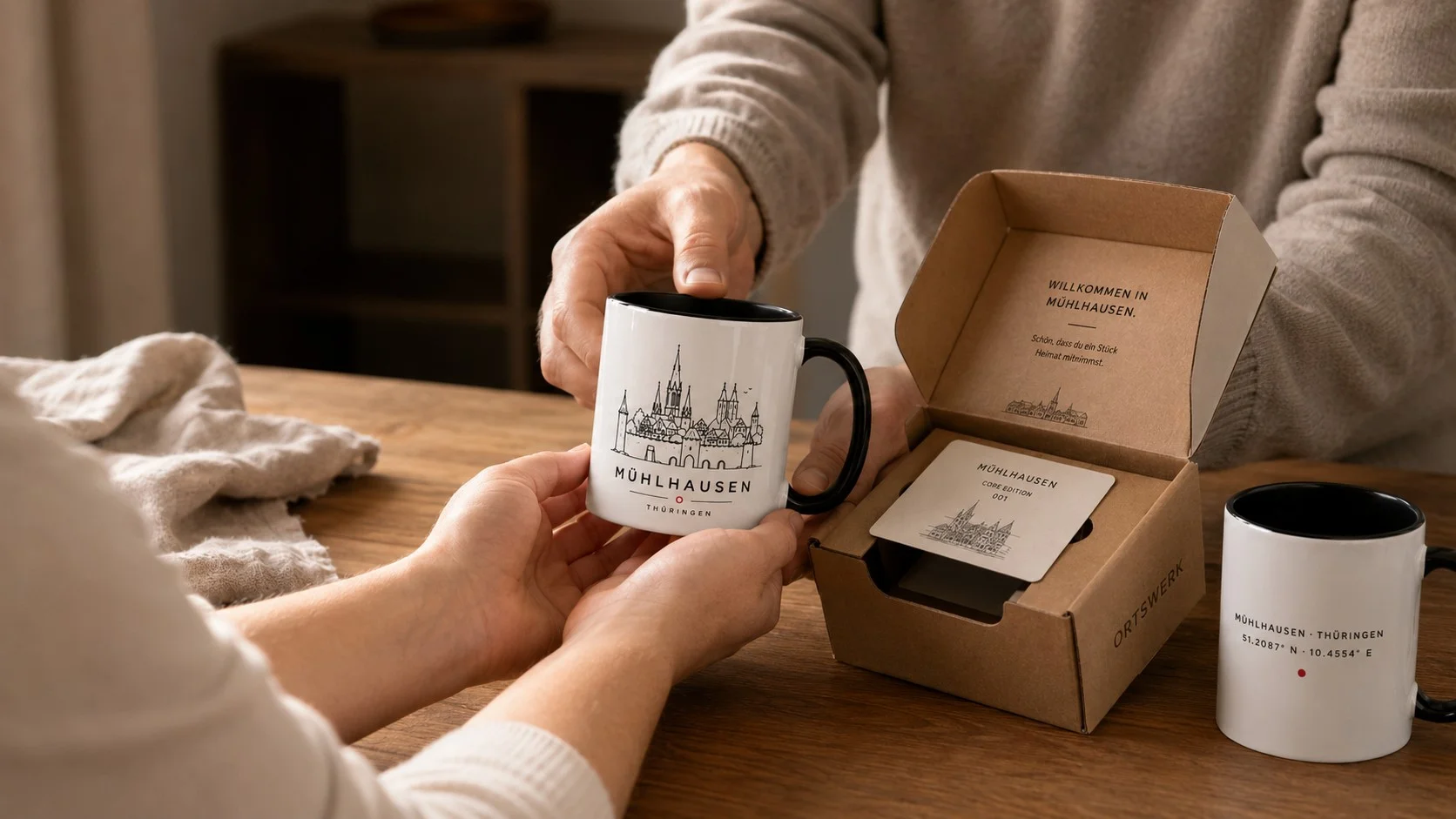 Übergabe einer ORTSWERK Mühlhausen-Tasse mit Kraftkarton-Verpackung